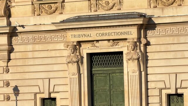 Historic stone facade of the Palais de Justice building from across the Seine riverbanks in Paris