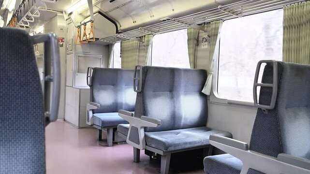 誰もいないローカル線のレトロなボックスシートと窓の外を流れる車窓の風景