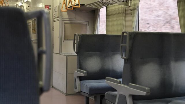 誰もいないローカル線のレトロなボックスシートと窓の外を流れる車窓の風景