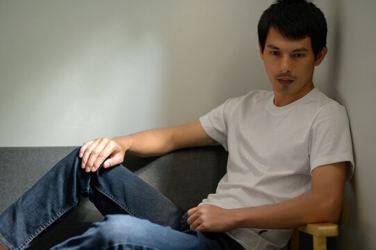 Casual Young Man Relaxing on Couch in Soft Natural Light