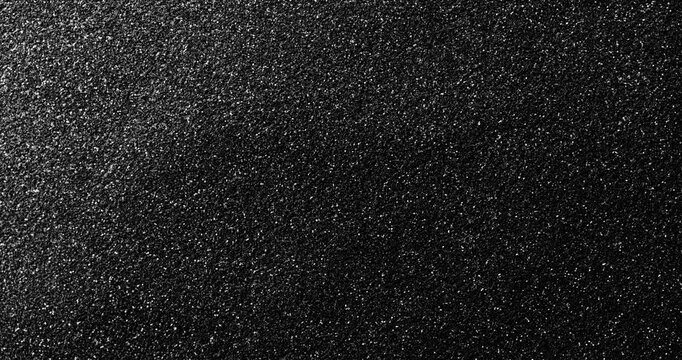 Dark Rough Texture. Subtle continuous movement across a deep black rough textured surface with fine grain and soft light gradients.