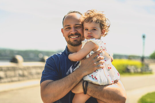 man playing with his baby outdoors in urban place