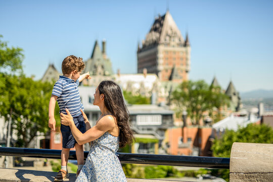 mother and son playing outdoors with chateau frontenac hotel in background