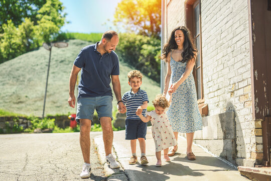 family of four people playing with childs outdoors in urban place