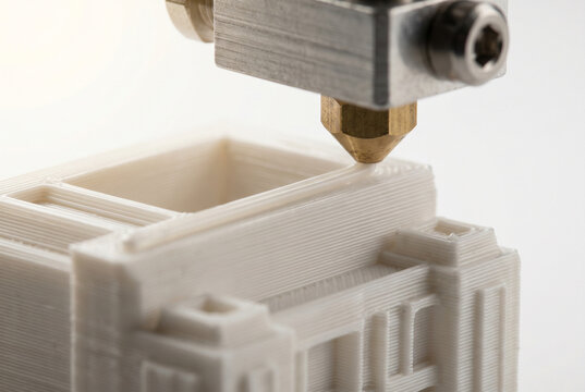 Buse d'une imprimante 3D en cours de fabrication d'une pi&egrave;ce blanche de pr&egrave;s