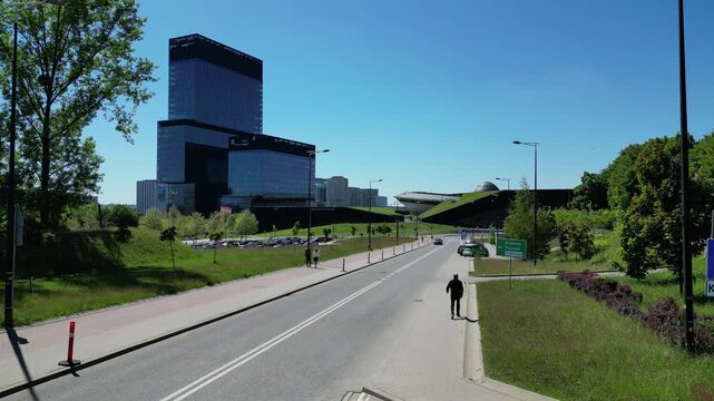 Smooth aerial drone shot of modern black skyscrapers and a convention centre with a sustainable green grass roof in Katowice, Poland.