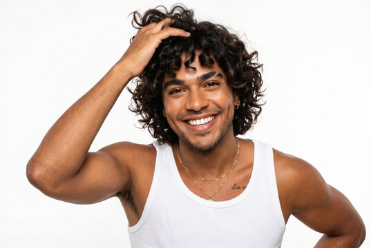 Happy young man with curly hair running hand through hair on white background