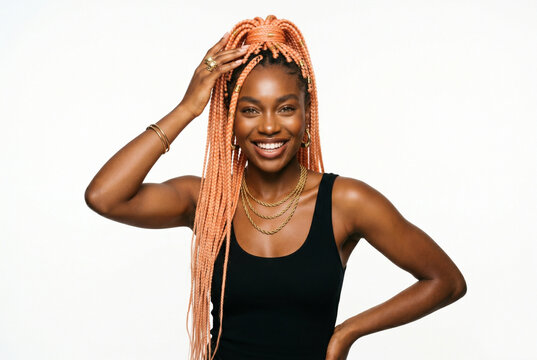 Radiant woman with long peach-colored box braids smiling confidently against a white background
