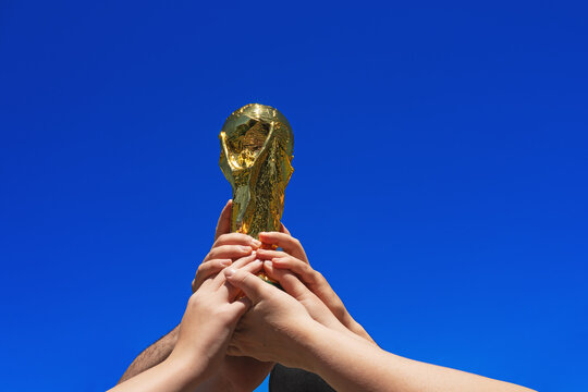01.05.26. Frankfurt am Main, Hesse, Germany. A hands lifts the World Cup Trophy above, isolated against a blue summer sky. A Celebration or win of Football.