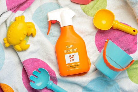 Top view of bottle of sunscreen 50+ and beach toys. Concept of sun protection
