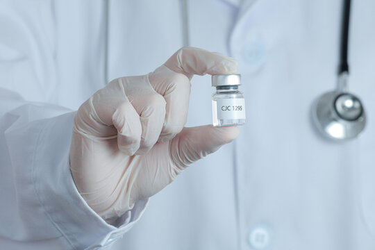 Serious professional doctor holding medical vaccine vial with peptide therapy represents hopeful future for global science medicine health