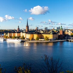 Obraz premium Historic Stockholm Skyline Stretching Along Calm Waterfront Under Blue Sky