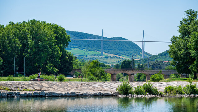 Millau, Aveyron, France : view of the Millau Viaduct spanning the Tarn Valley above the river and historic bridge in southern France.
