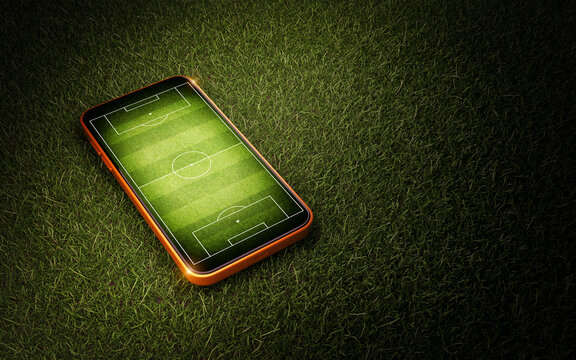 Mobile phone with soccer field screen on green grass lawn texture	