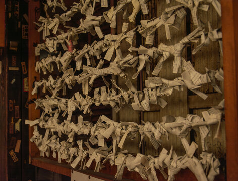 Omikuji fortune papers tied at a Japanese shrine at night