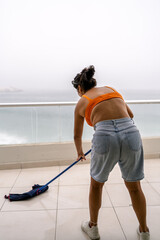 Obraz premium Woman cleaning balcony preparing beach house for summer