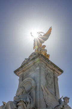 The Queen Victoria Memorial, a majestic landmark in front of Buckingham Palace, London, beautifully lit by sunlight, showcasing intricate sculptures and architectural elegance.