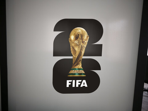 FIFA World Cup 2026 featuring the golden trophy on a white background wall display, Official logo and branding.
