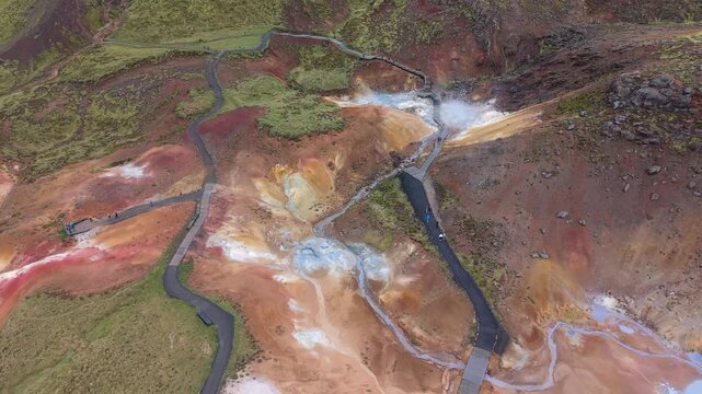 Stunning aerial footage of the vibrant, colorful landscape of the Seltun geothermal area in Krysuvik, featuring smoking fumaroles and mud pots