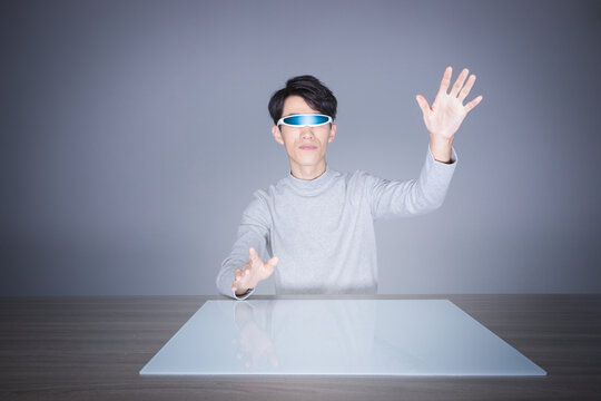 Young man using futuristic visor and virtual touchscreen interface