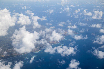 Aerial View of Tropical Caribbean Coastline Through Cumulus Clouds © Zach