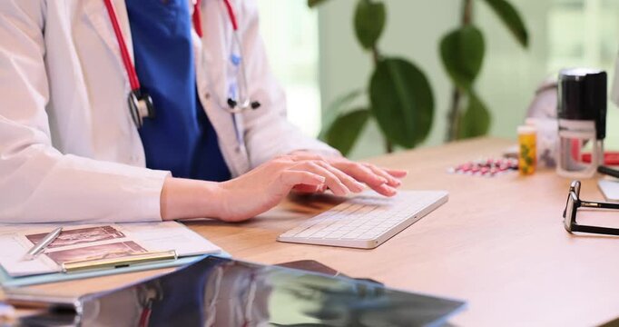 Female doctor hands type on computer keyboard filling digital medical forms in clinic. Woman physician checks patient symptoms online in hospital