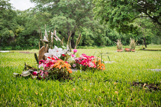 Arreglo floral sobre tumba en cementerio de Jujuy como s&iacute;mbolo de recuerdo y homenaje