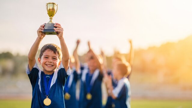 Child Soccer Player Lifting Trophy After Team Victory