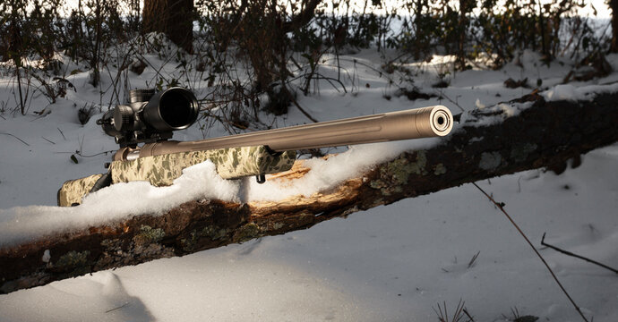 Snowy day bolt action rifle with camo stock outdoors