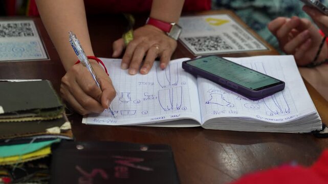 Tailor sketching designs in a Hoi An workshop
