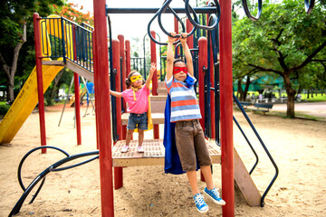 Two Asian children in superhero masks playing on jungle gym at park © Rawpixel.com