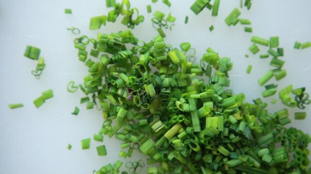 Close-up of a finely chop fresh green chives on a clean white cutting board