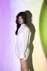 Fototapeta premium Young woman in white shirt with colorful projection light and shadow