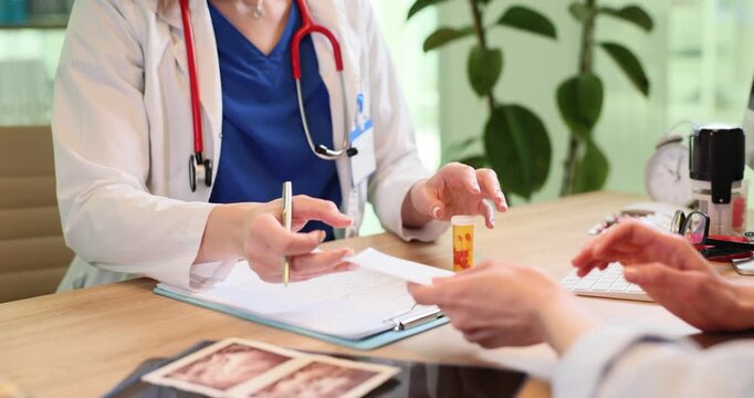 Doctor gives prescription for painkiller to patient at appointment in clinic. Female therapist prescribes drugs against disease to woman in hospital