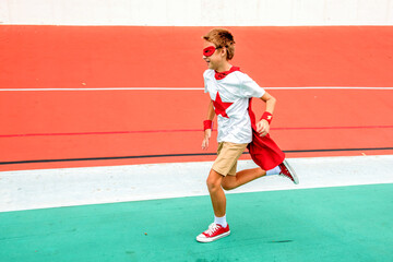 Obraz premium Boy in superhero costume running on a colorful track.