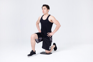 Obraz premium Athletic man doing kneeling lunge stretch warm up in studio