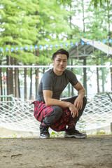 Fototapeta premium Athletic man crouching at outdoor obstacle course in forest park