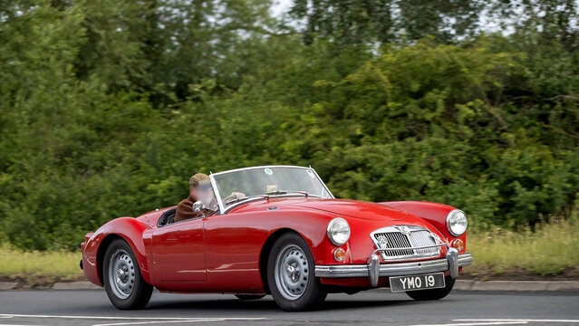 Stony Stratford,Bucks,UK - June 7th 2026:  1959 red MGA classic  car driving on a British road