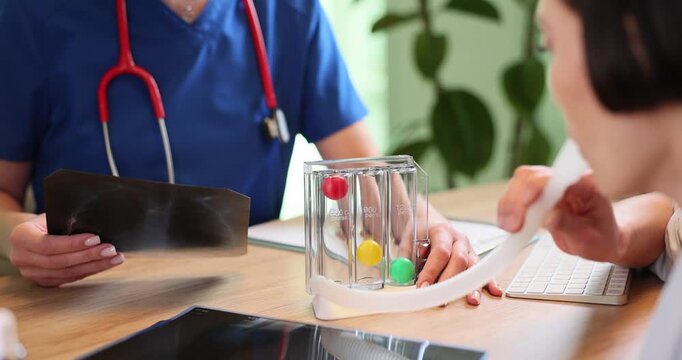 Woman blows into spirometer to indicate lung capacity in doctor office. Female patient undergoes breathing test with special equipment in hospital