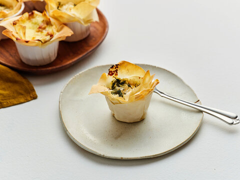 Spinach and cheese pastry cups served on a plate, perfect for dinner parties and casual gatherings