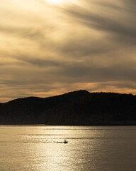 Golden sunset over a calm bay with a small boat and silhouetted mountains, Mediterranean Sea, Mallorca © Ricardo
