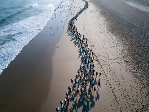Large Group Swimmers Running Into Ocean Surf Together
