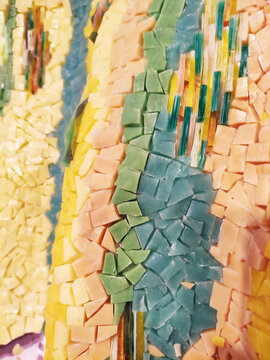 Close-up of a colorful mosaic made of ceramic fragments. Abstract texture, decorative art, handmade craftsmanship, detailed mosaic pattern.