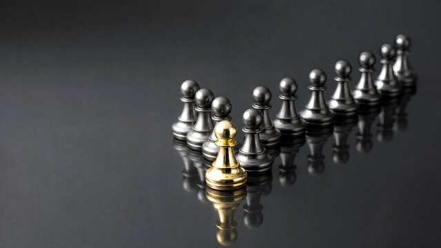 Gold Chess Pawn Leading Metallic Pieces in Arrow Formation