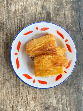 Crispy Fried Cassava or Singkong Goreng, Traditional Indonesian Snack Served on Vintage Enamel Plate