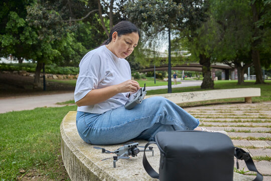 Woman adjusting drone setup outdoors