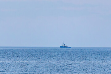 Fototapeta premium Lone ship sailing on the calm Adriatic Sea beneath a hazy sky, Italy, Roseto degli Abruzzi, 28 May 2026