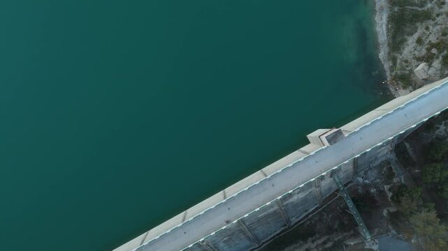 Top down drone shot flying over a concrete dam structure