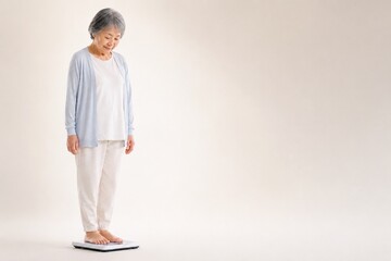 Fototapeta premium Senior Japanese woman checking her weight, mid shot