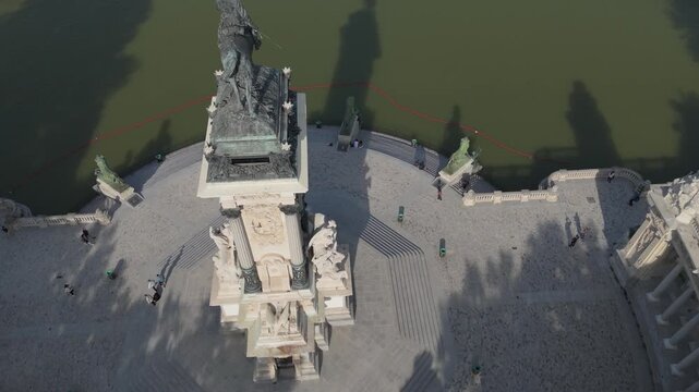 Top down aerial shot of Alfonso XII statue casting shadow on water